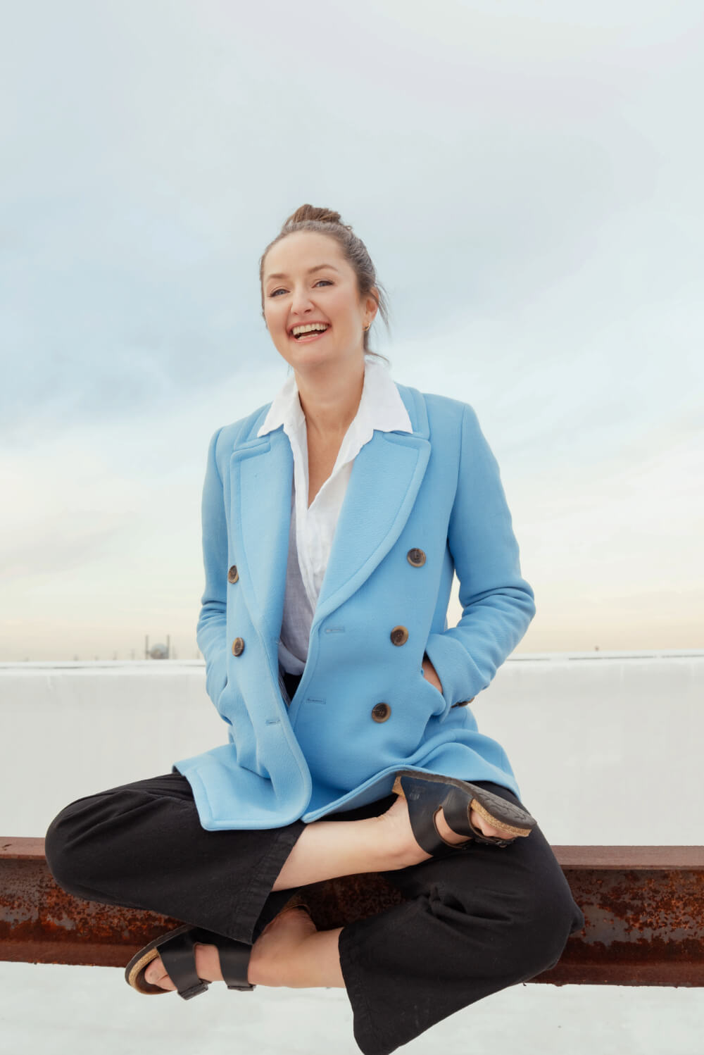 Cecelia - Sitting on the rail in a blue jacket laughing