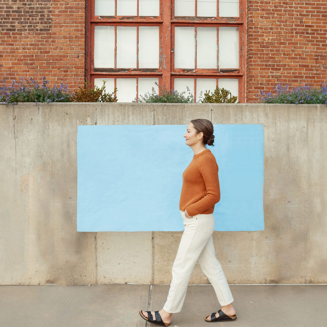 Cecelia Manrdyk walks infront of blue wall